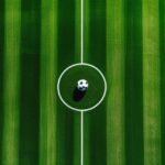 Anh flycam san co bong da nhin tu tren xuong voi mot qua bong o giua san, minh hoa tran giao huu Birmingham vs Barcelona